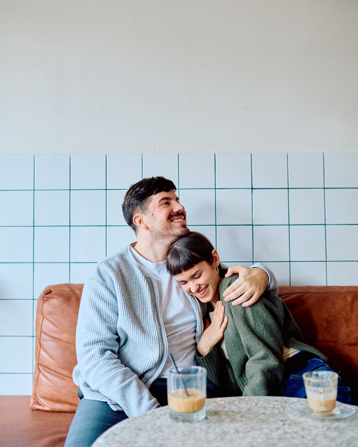 A couple laughing together over coffee at a local cafe